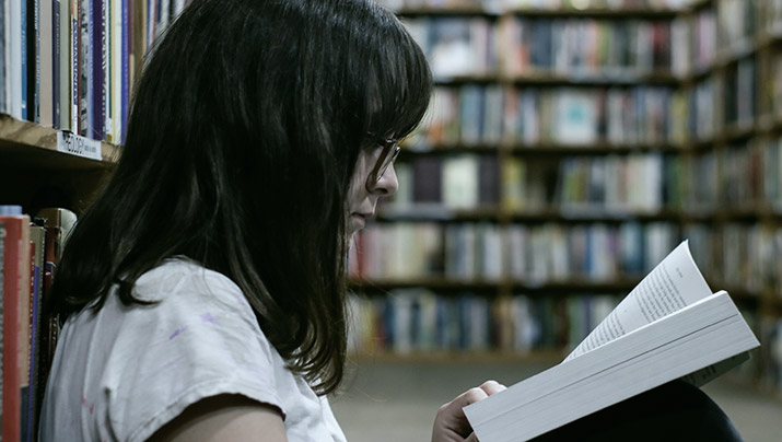 Adult learner reads in the library